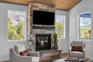 a living room with a fireplace with a flat screen tv at Desert Canyon Casita Near Zion Hot Tub Views in Orderville