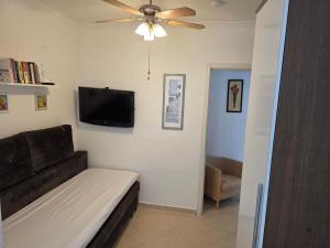 a living room with a couch and a flat screen tv at Sevinc Akasya Luxury Villa in Milas