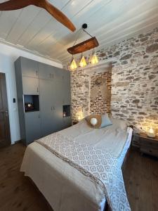a bedroom with a large bed and a brick wall at Filipa Gardens in Limenas
