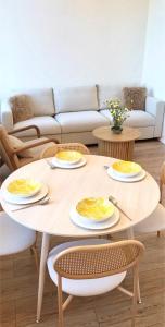 a table with plates and utensils on it in a living room at Sun Shine 1 apartment in Liepāja