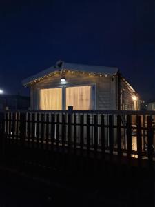 a small house with lights on it at night at Six Berth- Pet Friendly please ask Free WiFi Private secure decking - Sea front with amazing views Not to be missed in Rhyl