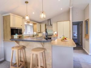a kitchen with a island with two bar stools at The Owlet in Llanidloes