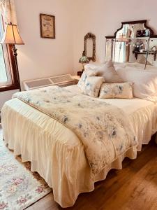 a bedroom with a large bed with white sheets at Maison Rose in Hudson