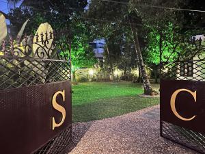 a gate with the initials s and a grass yard at Scarlet's Cottage & Tea Garden in Cochin