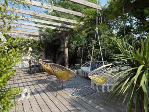 a patio with two chairs and a swing at Maison des conches in Longeville-sur-Mer
