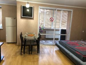 ein kleines Zimmer mit einem Tisch, einem Bett und einem Schlafzimmer in der Unterkunft 1 комнатная квартира студио возле ТРЦ Днепроплаза in Tscherkassy