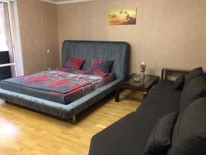 ein Schlafzimmer mit einem Bett, einer Couch und einem Tisch in der Unterkunft 1 комнатная квартира студио возле ТРЦ Днепроплаза in Tscherkassy + 6 Fotos