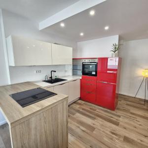 cocina con armarios rojos y nevera roja en Ziegel-Quartier APTNR 2, en Viersen