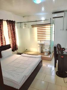 um quarto com uma cama grande e um WC em Epa's Place em Awoyaya