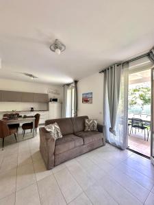a living room with a couch and a kitchen at Quadrivium Apartments in Castelnuovo del Garda