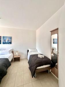 a bedroom with two beds and a mirror at Quadrivium Apartments in Castelnuovo del Garda
