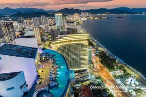 芽庄Panorama Nha Trang Residences by Luxanova的晚上可欣赏到酒店和大海的景色