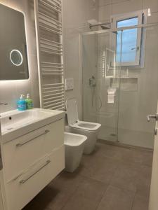 Un baño blanco con inodoro y ducha. en Venice Station Guest House, en Venecia 20 fotos más
