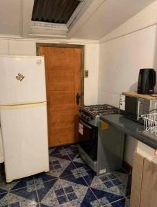 a kitchen with a refrigerator and a stove at Casa 3 a 5 personas estacionamiento privado in Temuco