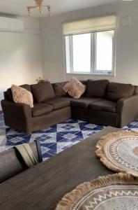 a living room with a brown couch and a table at Casa 3 a 5 personas estacionamiento privado in Temuco