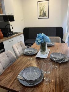 a wooden table with plates and wine glasses on it at City apartment Blue Vibes in Pula +24 photos
