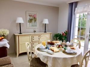 ein Esszimmer mit einem Tisch mit Essen darauf in der Unterkunft Chambres d'hôtes La Rose Des Sables in Les Herbiers