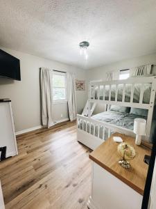 a bedroom with a white bed and a table at Newly Renovated Home With Pool in Omaha