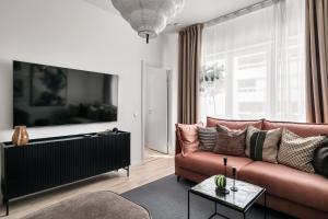 ストックホルムにあるStylish Luxe home by the waterのソファとテレビのあるリビングルーム