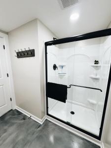 a bathroom with a glass shower in a room at Newly Renovated Home With Pool in Omaha