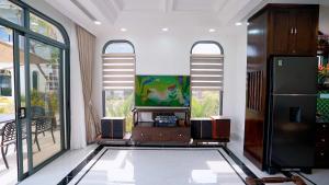 a living room with a tv and some windows at Annam Villa Sonasea Vân Đồn in Thâm Câu +4 photos