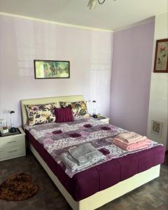 a bedroom with a large bed with purple sheets at Kuća na obali Save in Obrenovac +65 photos