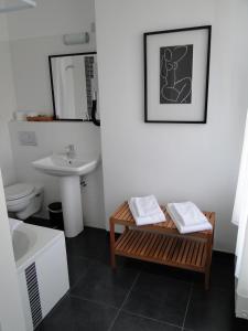 La salle de bains est pourvue d'un lavabo et d'une table avec des serviettes. dans l'établissement Hotel Malon, à Louvain