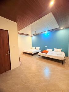 two beds in a room with a blue wall at Neelkanth Resort in Ukhimath
