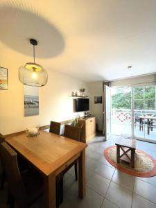 a dining room and living room with a wooden table at Résidence Belle Dune - maeva Home - Appartement chaleureux 2 pièces 4 personnes - Prestige MAE-8313 in Fort-Mahon-Plage