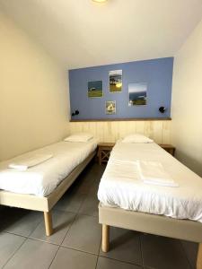two beds in a room with blue walls at Résidence Belle Dune - maeva Home - Appartement chaleureux 2 pièces 4 personnes - Prestige MAE-8313 in Fort-Mahon-Plage