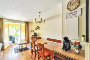 a kitchen and dining room with a table and a clock at La résidence du Lac - maeva Home - Maison 3 pièces 6 personnes - Prestige MAE-1083 in Monflanquin