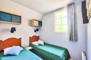 a bedroom with two beds and a window at La résidence du Lac - maeva Home - Maison 3 pièces 6 personnes - Prestige MAE-1083 in Monflanquin