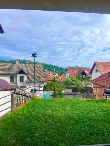 Una vista de un campo de césped con casas. en Iza-bella 2, en Brasov