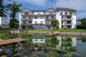 un grande edificio bianco con un laghetto di fronte di Apt MehrMeer DG mit Sauna Pool Fitness a Sassnitz