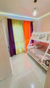 a room with two bunk beds with rainbow curtains at Porto Matrouh Unique Chalet 81001 in Marsa Matruh