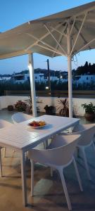 a table and chairs under an umbrella on a patio at Maria Studios in Parikia