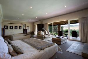 a bedroom with a large bed and a bath room at Blue Gum Country Estate in Stanford