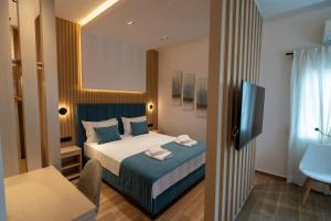 een hotelkamer met een bed en een televisie bij Azzuro in Fanárion