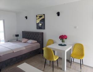 a bedroom with a bed and a table and chairs at Darija in Herceg-Novi