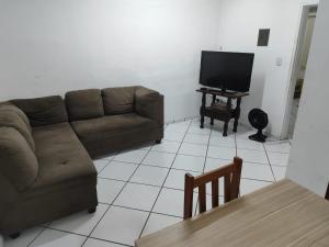 a living room with a couch and a television at Casa a pé da praia do Forte e Passagem Cabo Frio in Cabo Frio