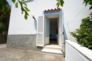 an open door of a white house with a window at Panorama Carmelina in Ischia
