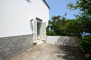 an open door on a white building with trees at Panorama Carmelina in Ischia