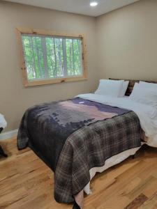 a bedroom with a large bed with a window at Treehouses at Lake Mountain Manor in Princeton