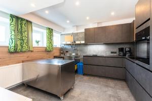 een grote keuken met roestvrijstalen apparatuur en houten kasten bij Appartements am Edthof in Eben im Pongau