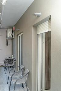 a room with chairs and a table with a window at Cozy Garden View Apartment in Paralia in Paralia Katerinis
