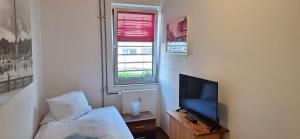a bedroom with a tv and a bed and a window at Hotel Spilburg in Wetzlar +21 photos