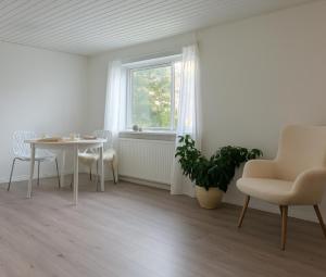 a living room with a table and chairs and a window at Guldmark in Lemvig