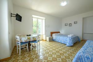 a bedroom with a bed and a desk and a table at Panorama Carmelina in Ischia +15 photos