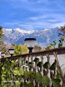 a wall with three lights on it with mountains in the background at SAAR Palampur Villa 5 BHK With Dhauladhaar Mountains View in Pālampur