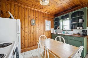 a kitchen with a table and a refrigerator at Light-Filled Near the Shore in Oscoda
